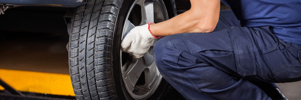 Hombre cambiando neumáticos de coche por reparación de pinchazo